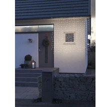 Hausfassade mit Lichterkette, Haustür, Briefkasten und Steinmauer