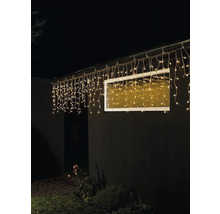 Hausfassade mit beleuchteter Lichterkette unter dem Dach