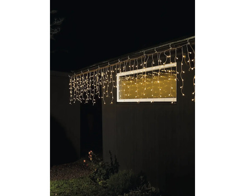 Hausfassade mit beleuchteter Lichterkette unter dem Dach
