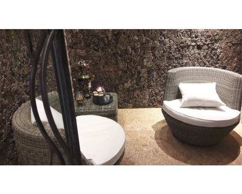 Wohnbereich mit Korbsesseln, Beistelltisch und Dekorationsartikeln vor einer Wand