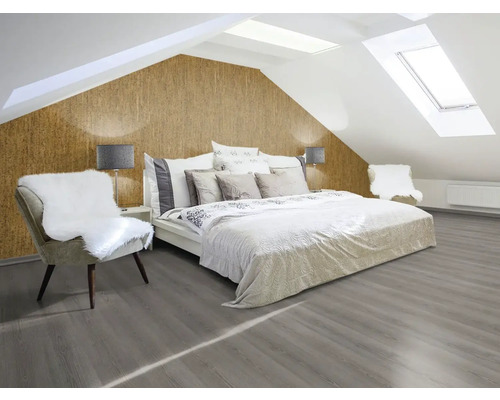 Helles Schlafzimmer mit Dachschrägen, Korktapete, Bett, Stuhl und grauem Holzboden