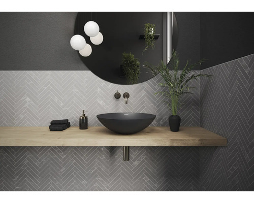 Modernes Badezimmer mit Waschtisch, Spiegel, Beleuchtung und grauen Fliesen in Fischgrätmuster