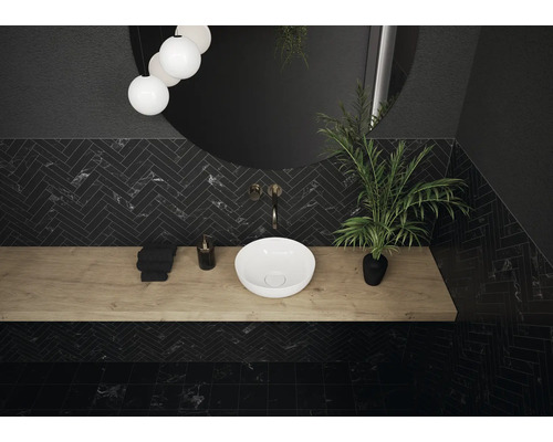 Badezimmer mit schwarzem Fischgrätenmuster, Waschtisch aus Holz, Aufsatzwaschbecken und rundem Spiegel
