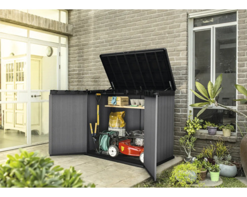 Geöffneter Geräteschrank mit Gartengeräten, Rasenmäher und Regalen