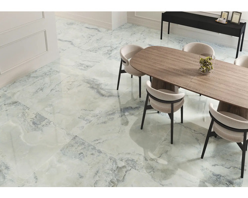 Heller Raum mit Fliesen in Marmoroptik, Esstisch und Stühlen.