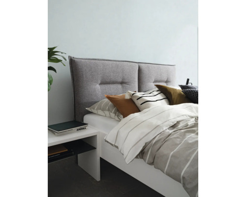 Bett mit gepolstertem Kopfteil, Bettwäsche und Nachttisch
