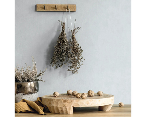 Dekorative Szene mit Holzhocker, Kräutern und Nüssen.