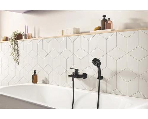 Badezimmer mit Badewanne, Armatur und geometrischen Fliesen