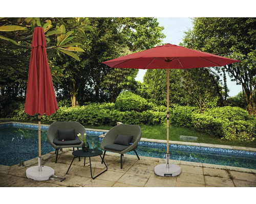 Szene mit zwei Gartensesseln, einem kleinen Tisch, einem offenen und einem geschlossenen Sonnenschirm neben einem Pool