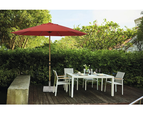 Gartenszene mit rotem Sonnenschirm, Gartentisch und Stühlen auf einer Terrasse