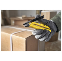 Ein gelbes Stanley-Teppichmesser in einer Hand mit Arbeitshandschuhen.