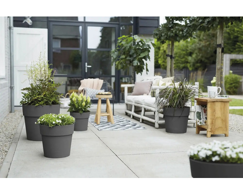 Terrasse mit bepflanzten Blumentöpfen und Sitzgelegenheiten im Freien