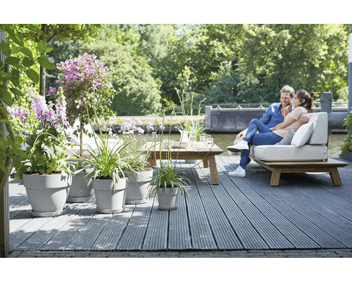 Terrassengestaltung mit Holzterrasse, Sitzmöbeln und Bepflanzung in Pflanzkübeln für eine entspannte Atmosphäre im Freien.