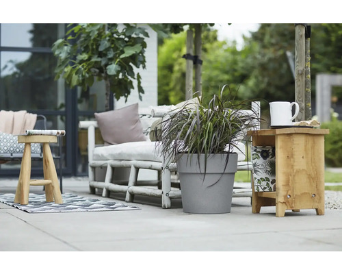 Gartenszene mit Sitzbank, Pflanztopf, Hocker und Beistelltisch im Außenbereich