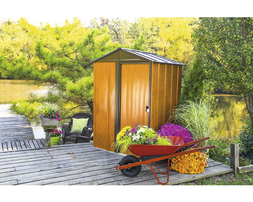 Gartenszene mit Gerätehaus, Schubkarre und Blumen auf einem Holzsteg
