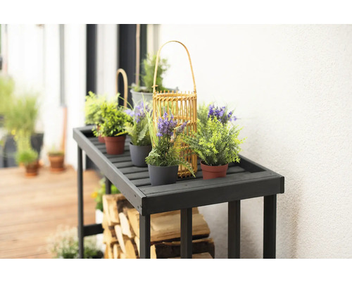 Dekorativer Holztisch mit Pflanzen und Brennholz für den Außenbereich