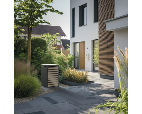Mülltonnenbox auf gepflastertem Weg vor einem Haus mit Garten