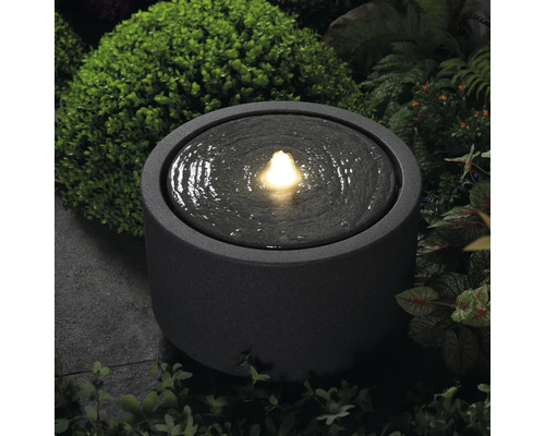 Runder Springbrunnen mit Wasser und Beleuchtung für den Garten