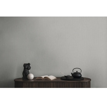 Tapete an einer Wand mit Kommode, Skulptur, Buch und Teeset