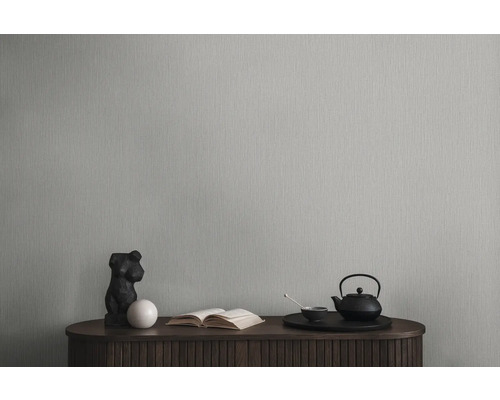 Tapete an einer Wand mit Kommode, Skulptur, Buch und Teeset