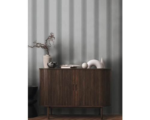 Kommode aus Holz mit Dekorationsgegenständen und gestreifter Tapete