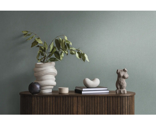 Dekoratives Interieur mit Vase, Skulpturen und Büchern auf einem Holzschrank