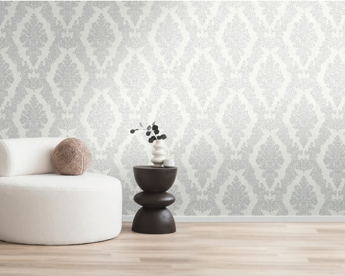 Wand mit gemusterten Tapeten, Sessel und Beistelltisch