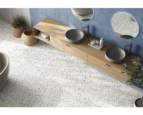 Badezimmer mit Doppelwaschtisch, runden Spiegeln, blauen Wandfliesen und Bodenfliesen in Terrazzo Optik