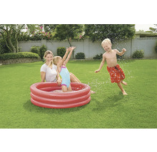 Familie mit aufblasbarem Planschbecken im Garten