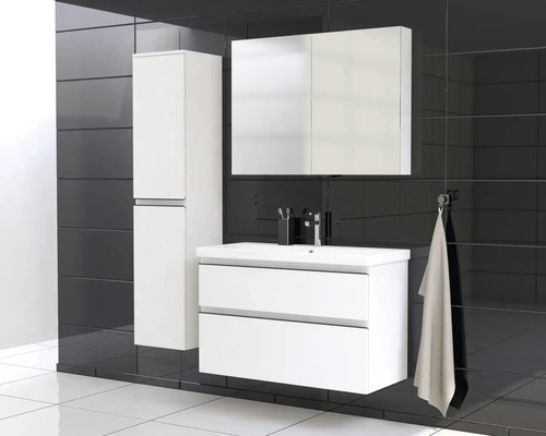 Modernes Badezimmerensemble mit Waschtischunterschrank, Spiegelschrank und Hochschrank vor schwarzem Fliesenhintergrund