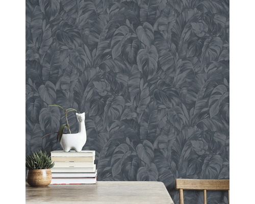 Wand mit dunkler Blättertapete, dekoriert mit Pflanzen und Büchern.