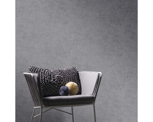 Graue Betonoptik Tapete mit Sessel und Dekokissen