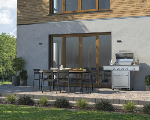 Außenbereich mit Grill, Gartentisch und Stühlen vor dem Haus