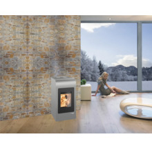 Wohnzimmer mit Pelletofen, Natursteinwand und Fenster mit Winterlandschaft