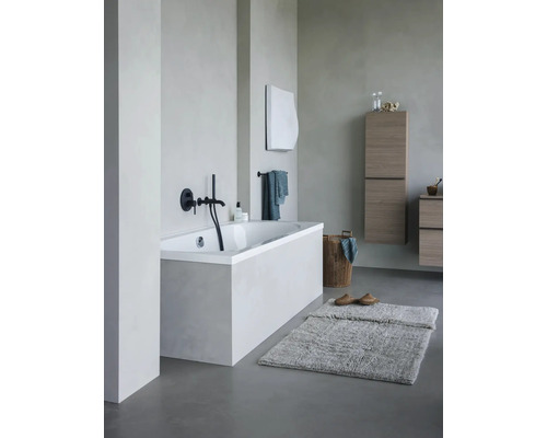 Helles Badezimmer mit Badewanne, Badmöbeln und Badteppich