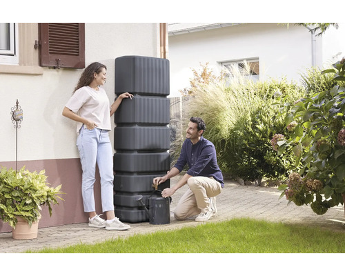Regenwassertank zur Gartenbewässerung mit zwei Personen und einer Gießkanne