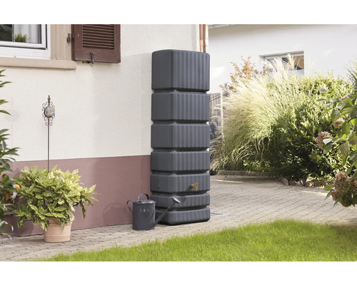 Grauer Regenwassertank mit Gießkanne im Garten