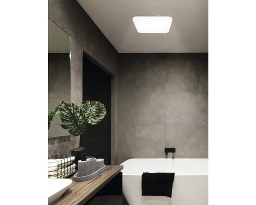 Badezimmer mit Badewanne, Waschtisch und Deckenleuchte