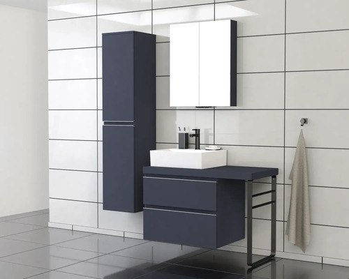 Badezimmer mit Waschtisch, Spiegelschrank und Hochschrank vor weiß gefliester Wand