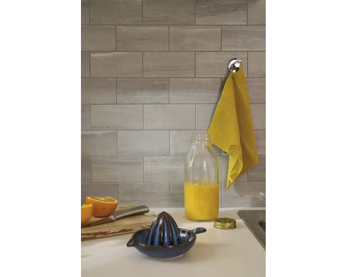 Graue Wandfliesen in einer Küche mit Saftpresse und Krug