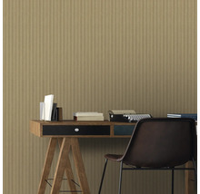 Szene mit Schreibtisch, Büchern, Schreibmaschine und Stuhl vor einer Wandtapete mit Holzstreifenmuster