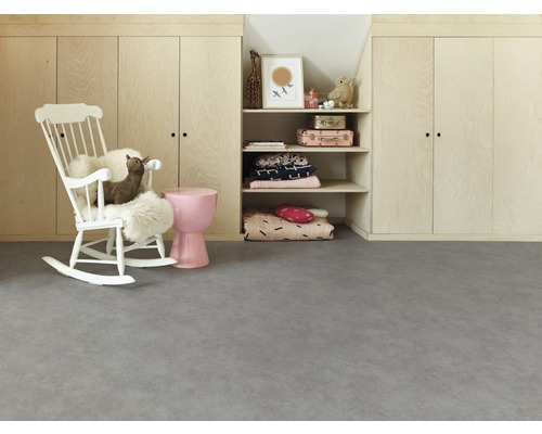 Kinderspielzimmer mit grauem Boden, Schrankwand aus hellem Holz und weißem Schaukelstuhl