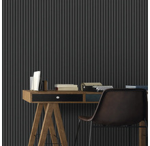 Ein Arbeitsbereich mit einem Schreibtisch, einer Schreibmaschine und einer vertikalen Lamellenwand