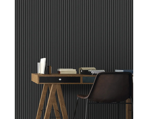 Ein Arbeitsbereich mit einem Schreibtisch, einer Schreibmaschine und einer vertikalen Lamellenwand