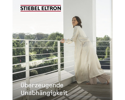 "Frau steht auf einem Balkon mit Geländer