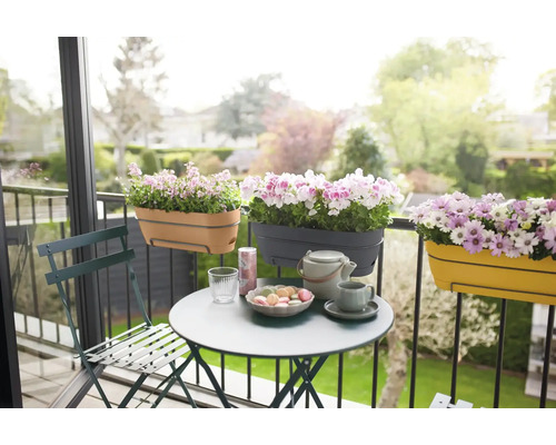 Balkonszene mit Tisch, Stuhl und Blumenkästen am Geländer