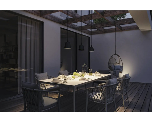 Terrasse mit Esstisch, Stühlen und Hängelampen unter einer Pergola