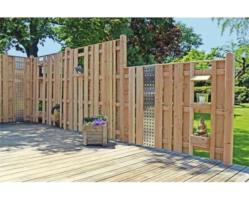 Holzzaun mit Pflanzkästen und Dekoration auf einer Terrasse