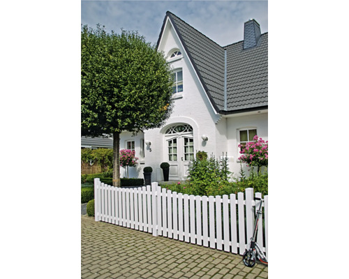 Weißer Holzzaun vor einem Haus mit Garten
