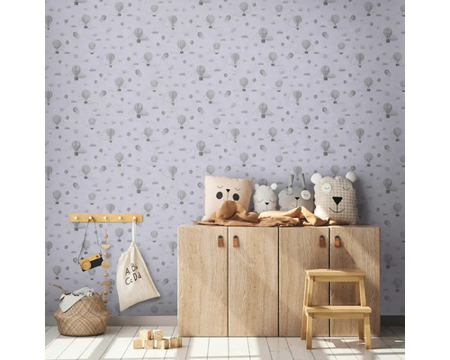 Kinderzimmer mit Tapete mit Heißluftballonmuster, Holzschrank und Spielzeugdekoration